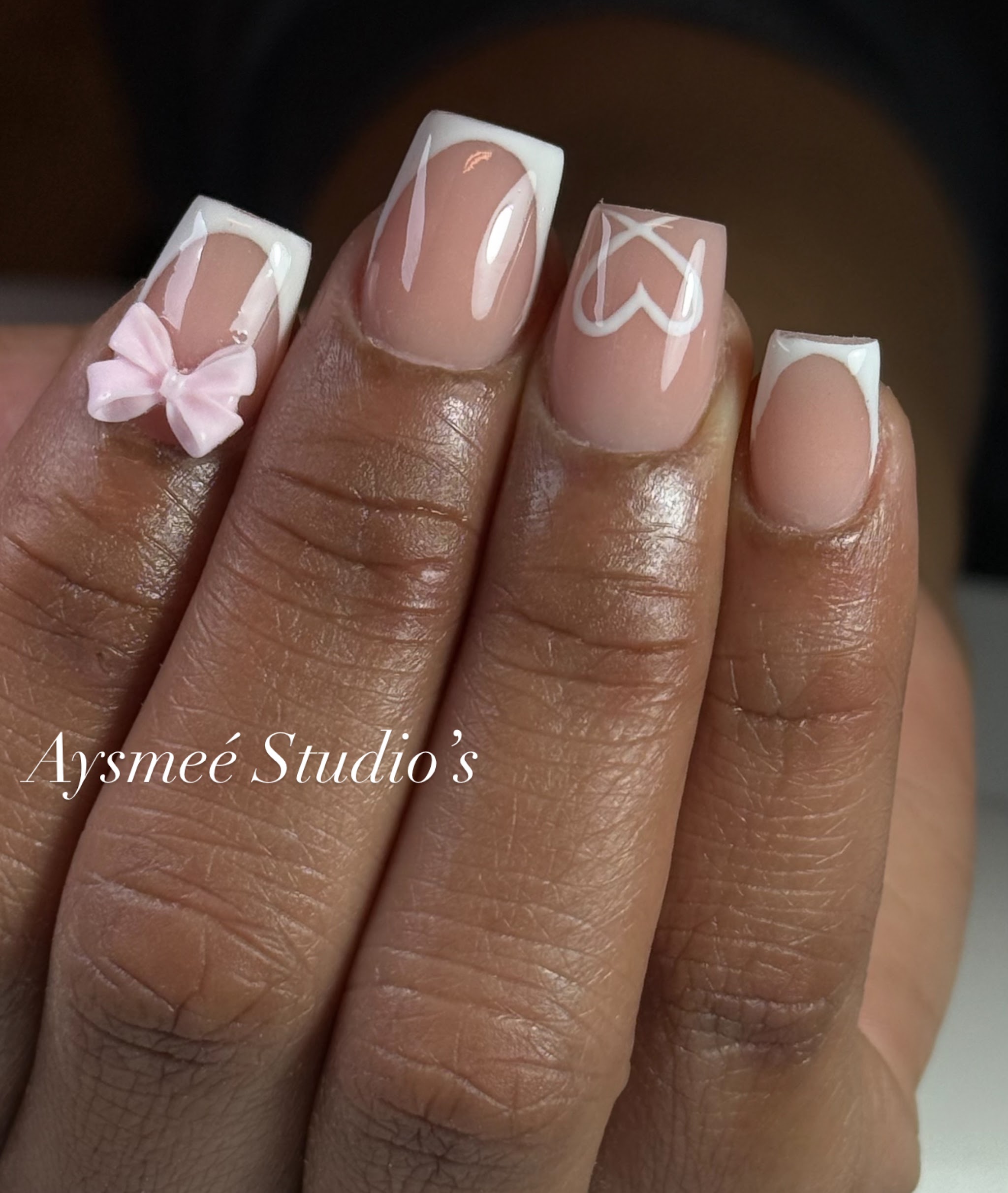 Korte French nagels met een roze strik en hartjes